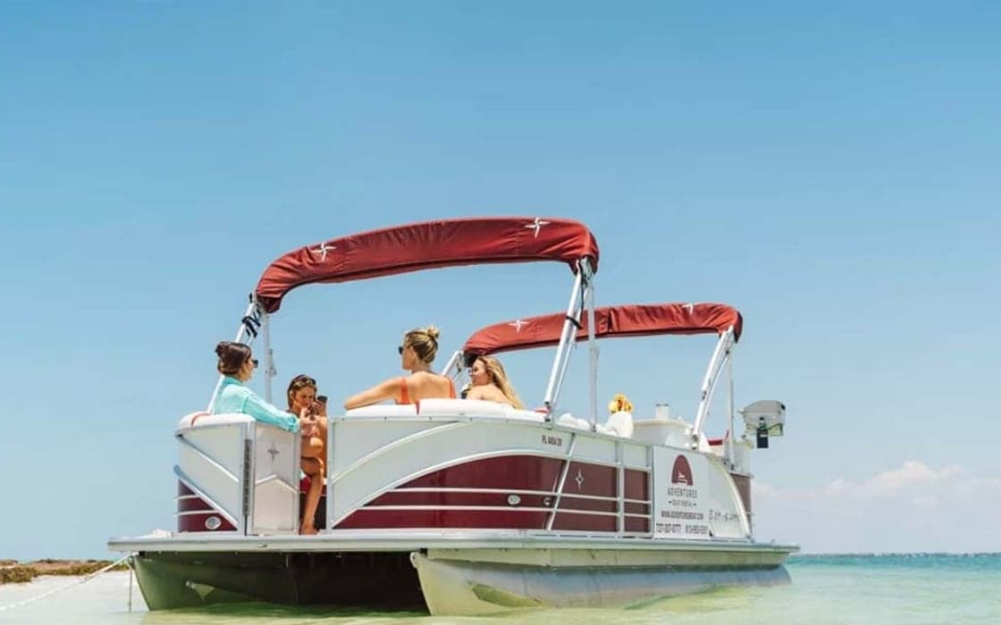 A Berkshire pontoon boat beached at a sandbar with guests aboard near Clearwater Beach